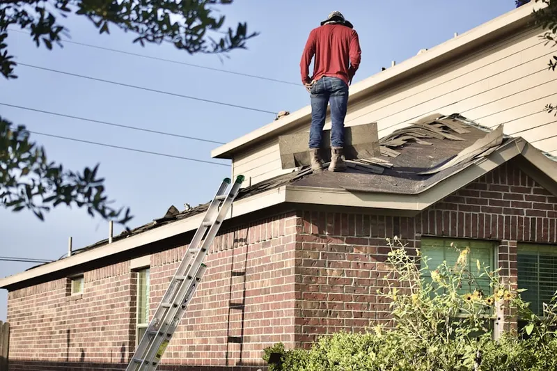 Professional roofer working on a residential roof in Weare